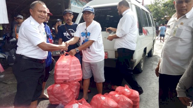 Kepala Kesbangpol Makassar, Ahmad Nansum menyerahkan bantuan makanan kepada korban banjir di Kecamatan Manggala, Rabu (23/01/2019).