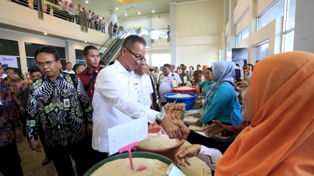Menteri Sosial RI, Agus Gumiwang Kartasasmita mebyalami warga saat penyaluran Bantuan Sosial Non Tunai Program Keluarga Harapan dan Bantuan Pangan Non Tunai, di Celebes Convention Center Makassar, Rabu (06/02/2019).