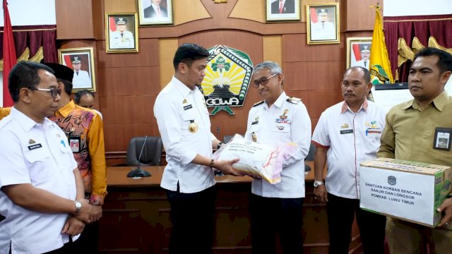 Bupati Luwu Timur, Thorig Husler menyerahkan secara simbolis bantuan logistik untuk korban bencana banjir dan longsor kepada Bupati Gowa, Adnan Purichta Ichsan, di posko induk, Baruga Pattingalloang, Kantor Bupati Gowa, Rabu (06/02/2019).