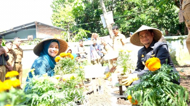 Bupati Gowa Adnan Purichta Ichsan bersama Isterinya Priska Paramita Adnan menanam bunga merry gold di halaman kantor PKK Gowa, Senin (11/02/2019).