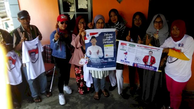 Warga Kecamatan Pammana Kabupaten Wajo, memegang banner yang Calon Anggota DPR RI, Andi Arsyil Rahman Putra, Kamis (28/03/2019).