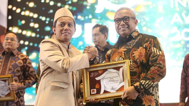 CEO PR Indonesia Asmono Weikan, menyerahkan penghargaan PRIA 2019 kepada Kepala Bagian Humas dan Kerjasama Pemkab Gowa Abdullah Sirajuddin, di Hotel Trans Luxury Bandung, Kamis (28/03/2019).