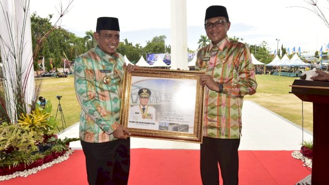 Gubernur Sulsel, Nurdin Abdullah, mendapat cenderamata dari Bupati Wajo, Amran Mahmud, pada perayaan HUT Kabupatem Wajo ke-620, di Lapangan Merdeka Wajo, Jumat (29/03/2019).