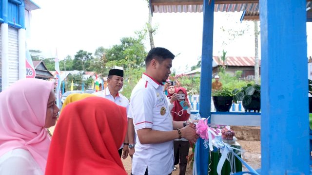 Bupati Gowa, Adnan Purichta Ichsan menggunting pita peresmian rumah data Kampung KB di Desa Sicini, Kecamatan Parigi, Sabtu (06/04/2019).