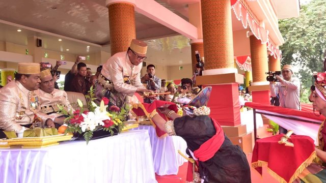 Gubernur Sulsel, Nurdin Abdullah menyerahkan salah satu benda pusaka kepada Bissu pada Ritual Mattompang Arajang, di Lapangan Merdeka, Watampone, Kabupaten Bone, Sabtu (06/05/2019).