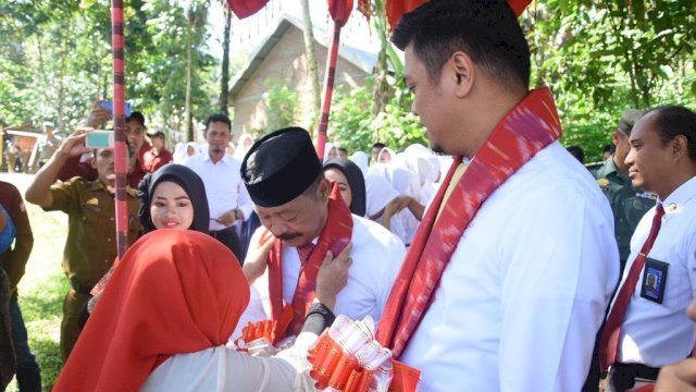 Bupati dan Wakil Bupati Gowa, Adnan Purichta Ichsan dan Abdul Rauf Malaganni dikalungi bunga saat melakukan kunjungan di Desa Tassese, Kecamatan Menuju, Senin (08/04/2019).