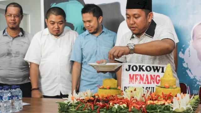 Ketua Repnas Sulsel, Herman Heizer memotong tumpeng kemenangan Jokowi-Ma'ruf, Minggu (21/04/2019).