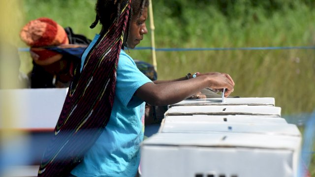 Seorang warga Papua memasukkan kertas suara di dalam kotak suara usan melakukan pencoblosan. (FOTO : Antara).