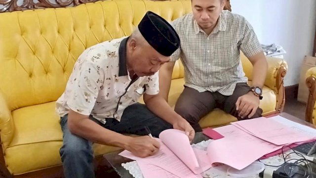 Kepala Desa Mattirowalie, Kecamatan Bengo Kabupaten Bone, Ruddin Tokkong (pakai peci), menandatangani administrasi eksekusi di Kejaksaan Negeri Watampone, Kamis (20/06/2019).