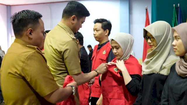 Bupati Gowa Adnan Purichta Ichsan memakaikan Jas Almamater secara simbolis kepada salah satu mahasiswi Unhas yang akan mengikuti KKN Reguler-Tematik Angkatan 102 Tahun 2019, di Baruga AP. Pettarani Unhas Makassar, Senin (24/06/2019).
