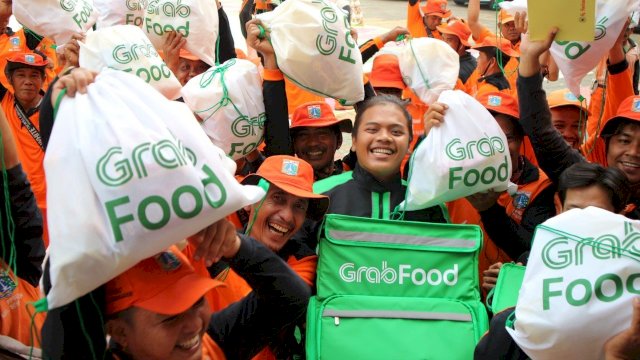 Petugas GrabFood bersama ratusan pasungan oranye merayakan HUT DKI Jakarta ke-492, Senin (24/06/2019).
