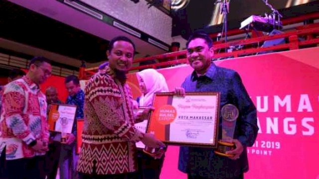 Wakil Gubernur Sulsel Andi Sudirman Sulaiman, menyerahkan piagam penghargaan kategori Kemitraan Media Terbaik tahun 2019 kepada Asisten II Pemkot Makassar, Andi Irwan Bangsawan.