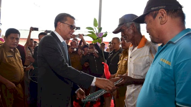 Gubernur Sulsel Prof. Nurdin Abdullah menyerahkan bantuan secara simbolis kepada nelayan.
