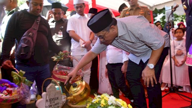 Ilham Arief Sirajuddin (IAS) menyiram kubur Ichsan YL, Kamis (01/08/2019).