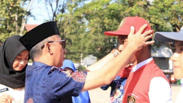 Sekda Kabupaten Gowa, Muchlis memakaikan atribut kepada salah satu anggota Paskibraka, Jumat (02/08/2019).