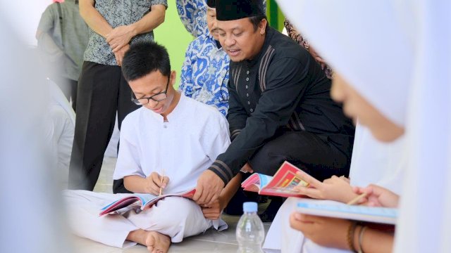 Wakil Gubernur Sulsel Andi Sudirman Sulaiman, menuntun salah satu siswa membaca Al-Quran, saat meresmikan Masjid Al-Qira'ah SMA Negeri 15 Makassar, Kecamatan Biringkanaya, Jumat (30/08/2019).