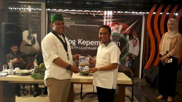 Ketua BPD Hipmi Sulsel Herman Heizer, menyerahkan buku 'Pengusaha Era Digital' kepada Ketua HMI Badko Sulselbar Lanyala Soewarno.