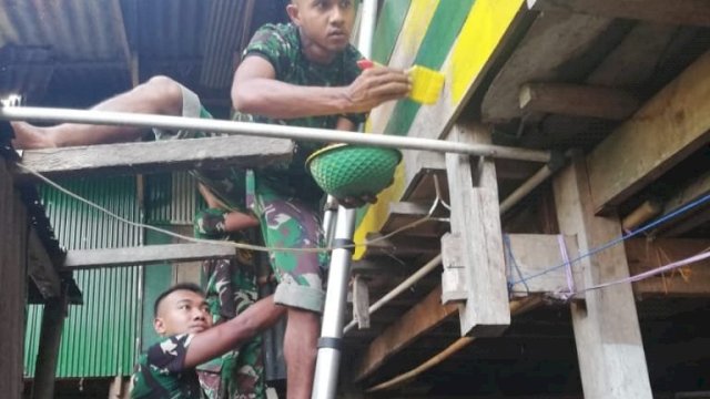Anggota TNI mengecat salah satu rumah Staf Desa Panincong, Rahmat, Selasa (29/10/2019).