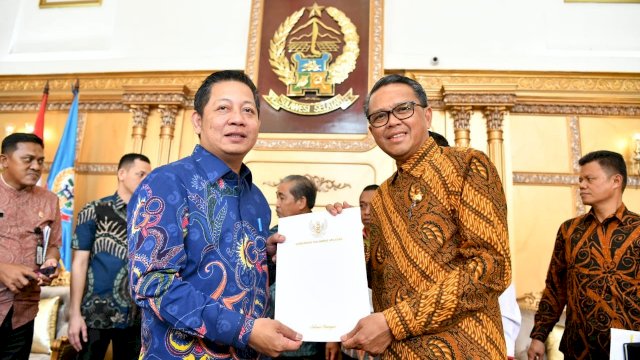 Gubernur Sulsel Prof. Nurdin Abdullah menyerahkan laporan progres pembangunan kepada Wakil Ketua Banggar DPR RI, Rusdi Masse, Kamis(12/12/2019).