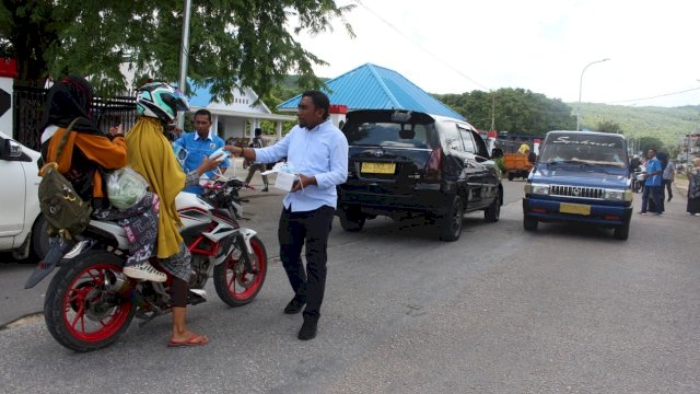 Ketua KNPI Kabupaten Buton Tengah (Buteng), Firman Kasim, membagikan masker kepada pengguna jalan di Depan Kantor Bupati Buteng, Kamis (19/03/2020).