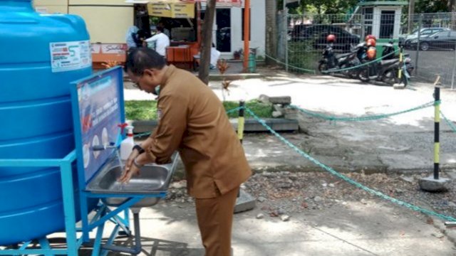 Penjabat Wali Kota Makassar Iqbal Suhaeb, mencuci tangan di Wastafel Portabel yang disediakan oleh PDAM Kota Makassar, di Halaman Lapangan Karebosi. (Ist)