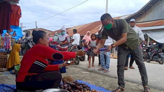 Anggota DPRD Sultra Ali Mardan, memberikan masker kepada salah satu Pedagang di Pasar Mawasangka, Kabupaten Buton Tengah, Sulawesi Tenggara, Sabtu (11/04/2020).