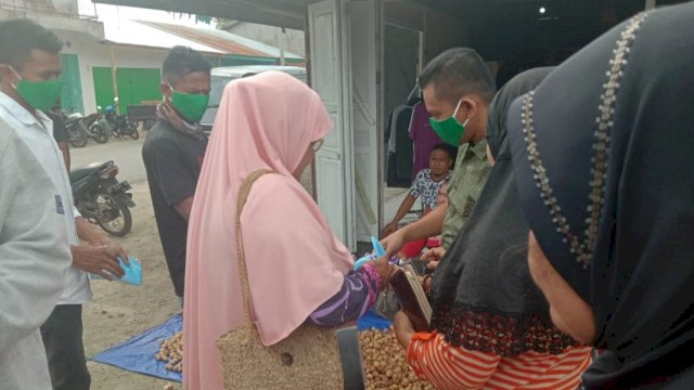 Warga berebut masker yang dibagikan Anggota DPRD Sultra Ali Mardan, di Pasar Mawasangka, Kabupaten Buton Tengah, Sabtu (11/04/2020).