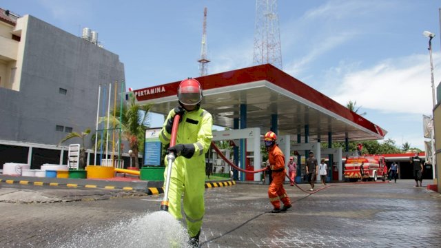 Penyemprotan cairan disinfektan di salah satu SPBU di Kota Makassar, Sabtu (28/03/2020).