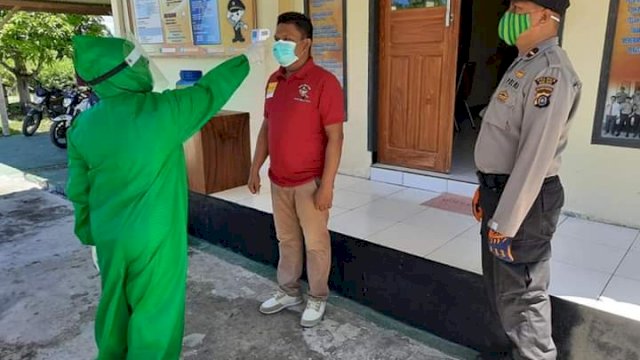 Petugas medis memeriksa kesehatan salah satu Anggota Polsek Mawasangka Timur (Mastim), Minggu (19/04/2020).