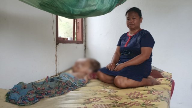 Nursiah (41) bersama anaknya penderita Hidrocepalus.