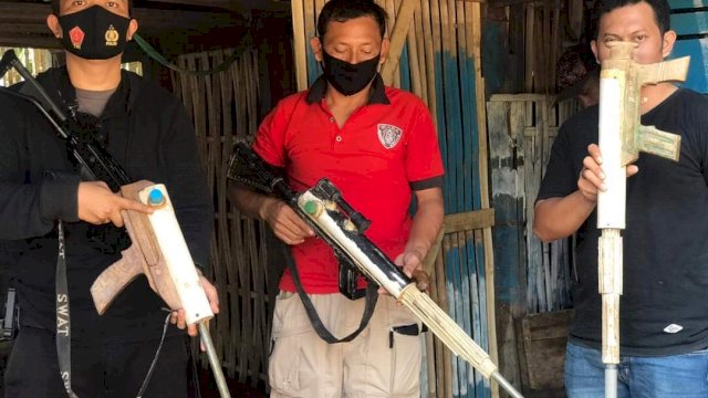 Anggota Polsek Lappariaja memperlihatkan tiga pucuk senjata rakitan.