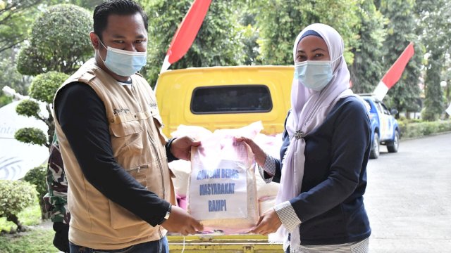 Camat Rampi, Suryadi Djafar menyerahkan bantuan beras secara simboliskepada Bupati Luwu Utara, Indah Putri Indriani. Bantuan beras sebanyak 1,2 ton dari masyarakat Rampi