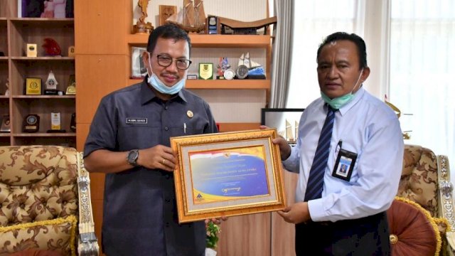 Pjs. Bupati Luwu Utara, Iqbal Suhaeb, saat menerima piagam penghargaan atas capaian opini WTP
