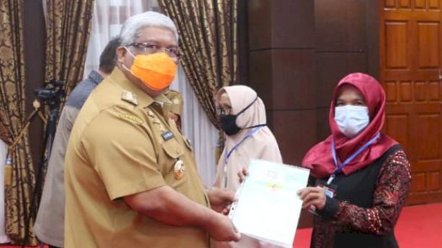 Gubernur Sultra Ali Mazi saat menyerah sertifikat tanah kepada perwakilan masyarakat. Foto: Ewit/ Kominfo Sultra