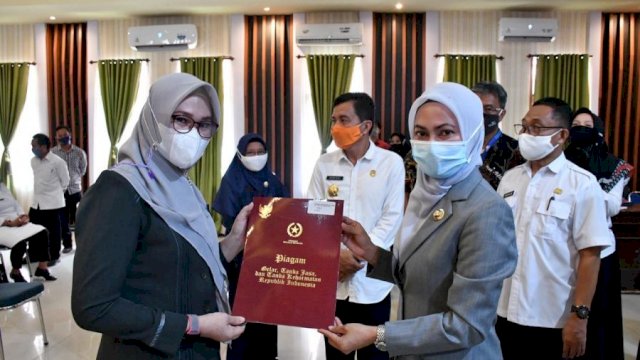 Bupati Indah menyerahkan penghargaan Satyalancana, kepada slah satu ASN lingkup Pemda Lutra.