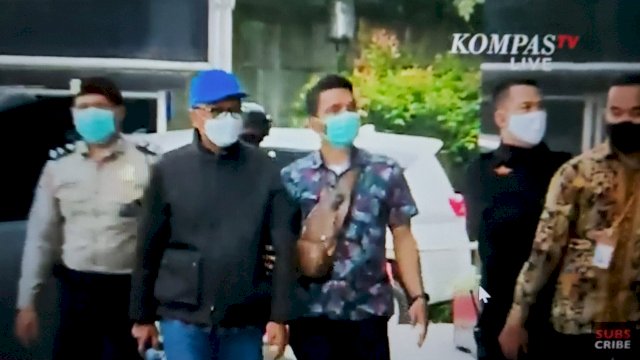 Gubernur Sulsel Prof. Nurdin Abdullah (topi biru), dikawal ketat Aparat Keamanan saat tiba di Gedung KPK, Jakarta, Sabtu (27/02/2021). (Keterangan Foto: Tangkapan Layar KompasTV yang menyiarkan langsung dari Gedung KPK).