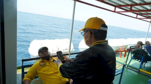 Ketua DPD I Partai Golkar Sulsel Taufan Pawe, memotret salah satu Kader Golkar Andi Atta Lantara, yang tertidur pulas di kursi Kapal Fery rute Pelabuhan Pamatata Selayar Ke Pelabuhan Bira Bulukumba, Senin (15/02/2021).