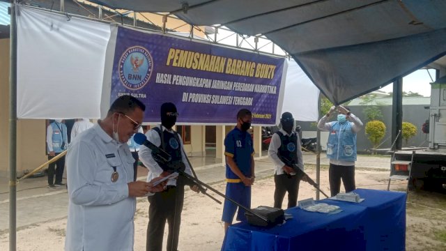 Kepala BNNP Sultra Brigadir Jendral Polisi Sabarudin Ginting S.IK bersama tersangka pengedar Narkoba saat pemusnahan barang bukti Narkoba hasil sitaan. Foto: Akbar Tanjung