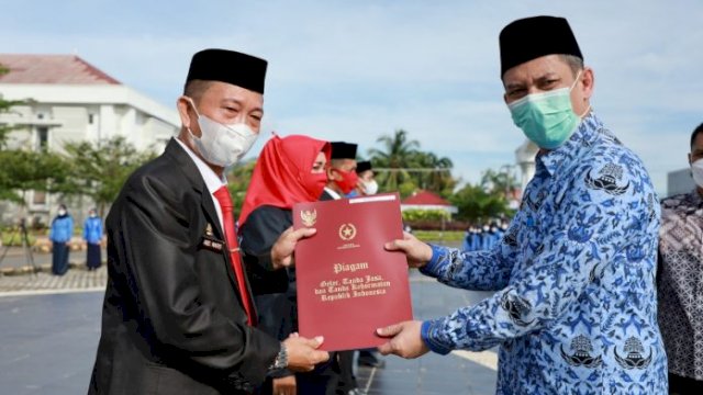 Sekretaris kota (Sekkot) Palopo, Drs. Firmanza DP, SH.,M.Si mewakili Walikota Palopo menyerahkan secara simbolis SK CPNS Formasi Umum Tahun 2019 di Halaman Kantor Walikota Palopo pada saat apel pagi, Jumat (15/1/2021).
