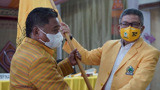 Ketua DPD I Partai Golkar Sulsel Taufan Pawe, menyerahkan bendera Golkar Kepada Ketua Golkar Toraja Utara yang juga Bupati Toraja Utara Terpilih Yohannis Bassang, Sabtu (27/02/2021).