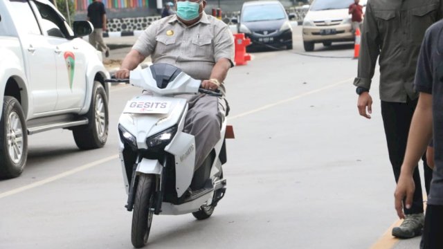 Gubernur Sultra Ali Mazi saat mencoba mengendarai Motor Listrik. Foto: Ewit Firmansyah/ Diskominfo Sultra