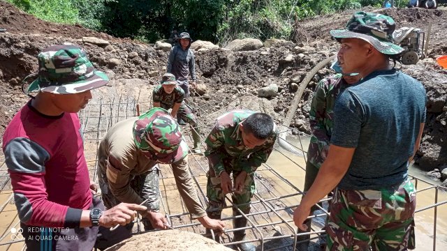 Gabungan anggota TNI, polri dan masyarakat saat mengerjakan pemasangan tiang jembatan pada program TNI Manunggal Membangun Desa di Kampung Allu, Dusun Tanakaraeng, Desa Tanakaraeng, Kecamatan Manuju, Kabupaten Gowa, Sabtu (06/03/2021). (Rhany)