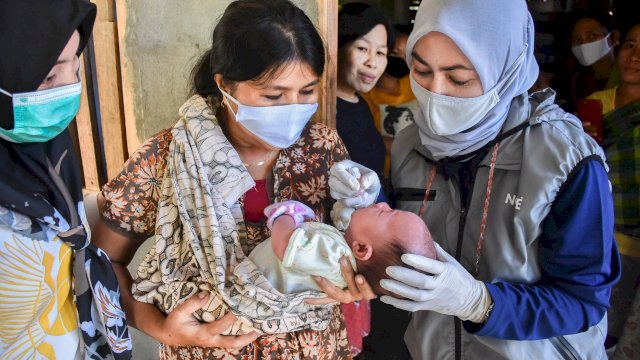 Bupati Luwu Utara Indah Putri Indriani memberikan vaksin polio tetes kepada Leri bayi 1,5 bulan di Dusun Pulao Desa Sassa. Sabtu (20/03/2021)