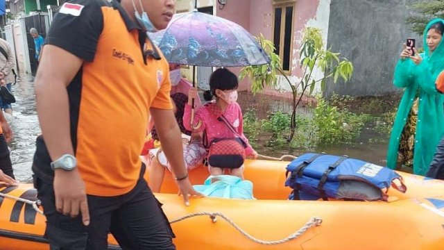 Tim Tanggap Bencana BPBD Kabupaten Gowa saat melakukan evakuasi kepada warga terdampak banjir. (Istimewa)