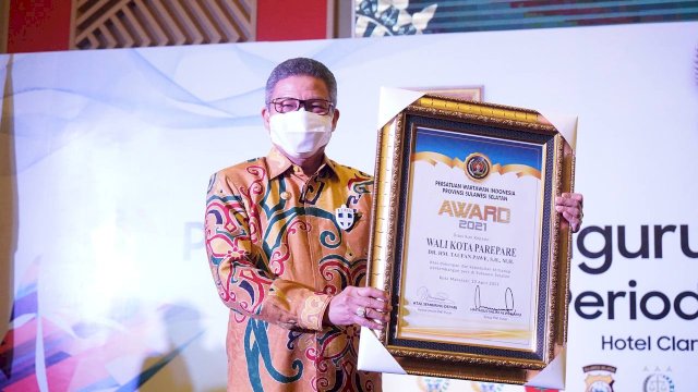 Wali Kota Parepare Taufan Pawe, memperlihatkan piagam penghargaan PWI Award, di Sandeq Ball Room Hotel Claro Makassar, Sabtu (10/04/2021).