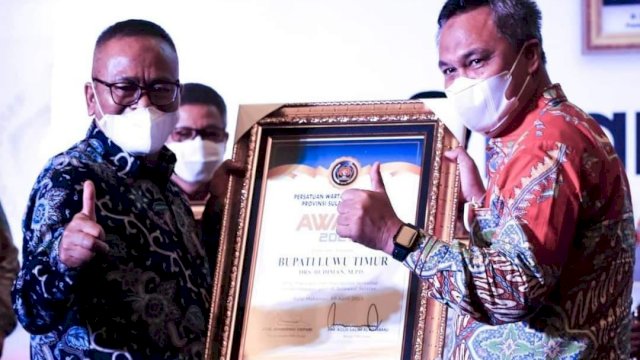 Bupati Luwu Timur Budiman Hakim, menerima Piagam PWI Award dari Ketua PWI Pusat Sembiring Depari, di Sandeq Ballroom Hotel Claro Makassar, Sabtu (10/04/2021).