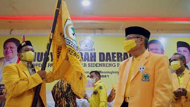 Zulkifli Zain menerim bendera Partai Golkar dari Ketua DPD I Taufan Pawe setelah terpilih aklamasi di Musda Golkar Sidrap, Minggu (25/04/2021).
