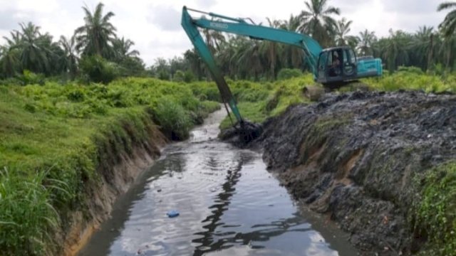 Salahh satu Eksavator milik Pemkab Asahan melakukan pengerukan saluran Air.