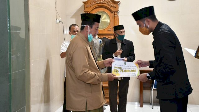 Bupati Sinjai Andi Seto Ghaditsa Asapa, menyerahkan bantuan uang tunai secara simbolis kepada pengurus Masjid Nurut Tijarah Kecamatan Sinjai Utara, Sabtu (01/05/2021).