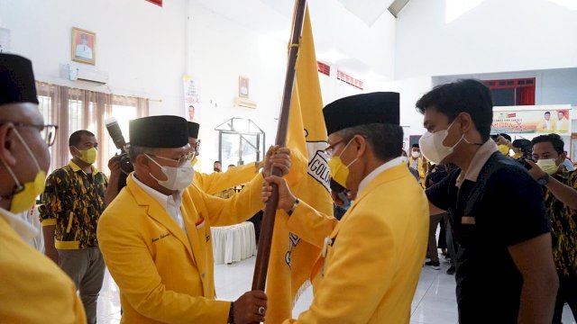 Ketua DPD I Golkar Sulsel Taufan Pawe, menyerahkan bendera Golkar kepada Ketua DPD II Jeneponto terpilih Iksan Iskandar, di Baruga Sipitangarri Jeneponto, Minggu (02/04/2021).